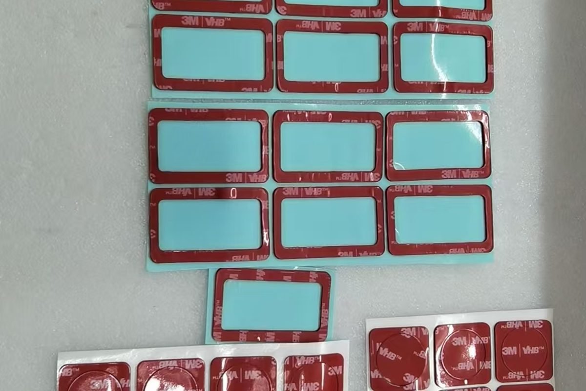 Die-cut and adhesive-bonded components staged for assembly