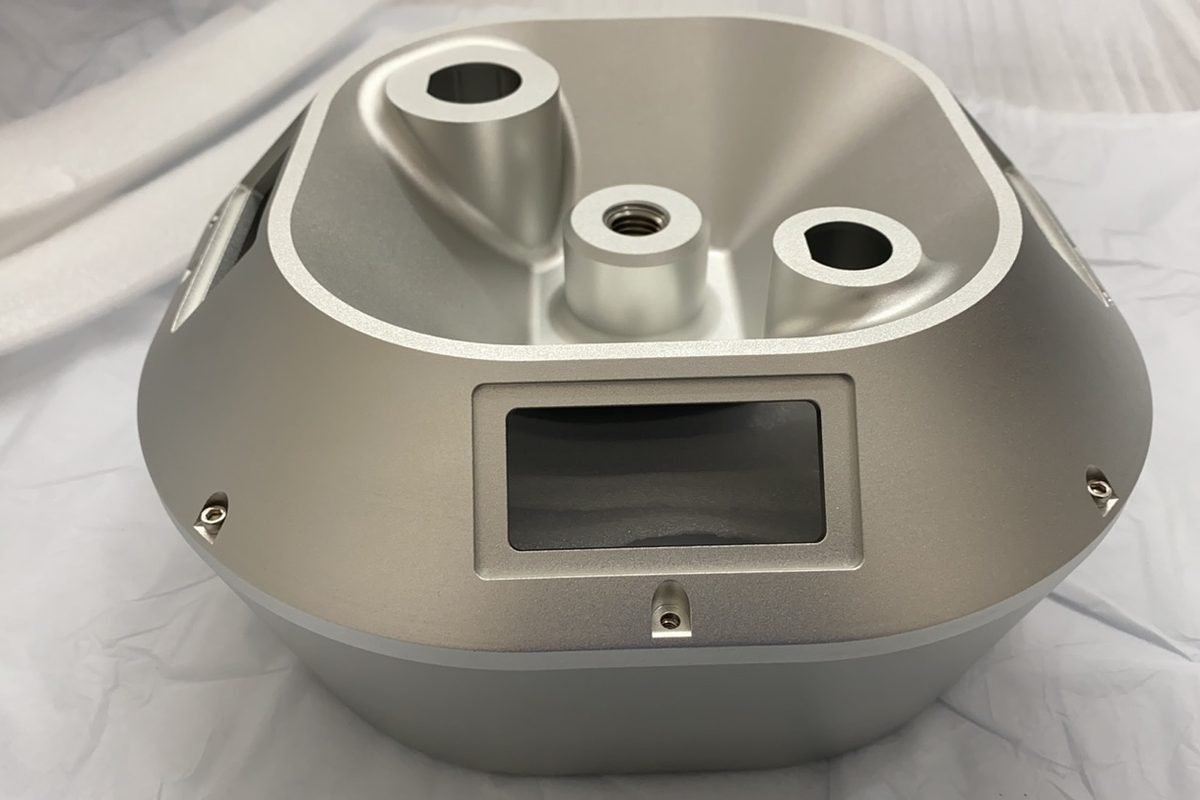 A machined aluminum component seen from the front